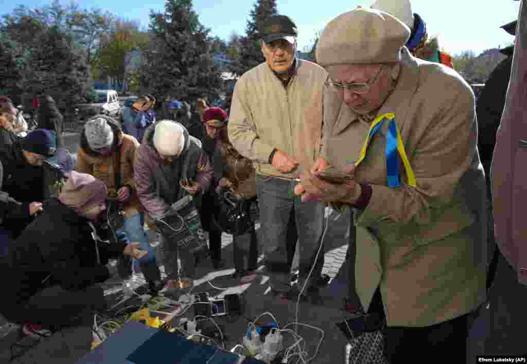 Liberated residents take advantage of a charging station in the central square. 