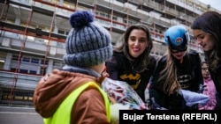 Dea Durmiši, obučena u kostim superheroja Betmena, daje poklon djetetu u dvorištu Pedijatrijske klinike.