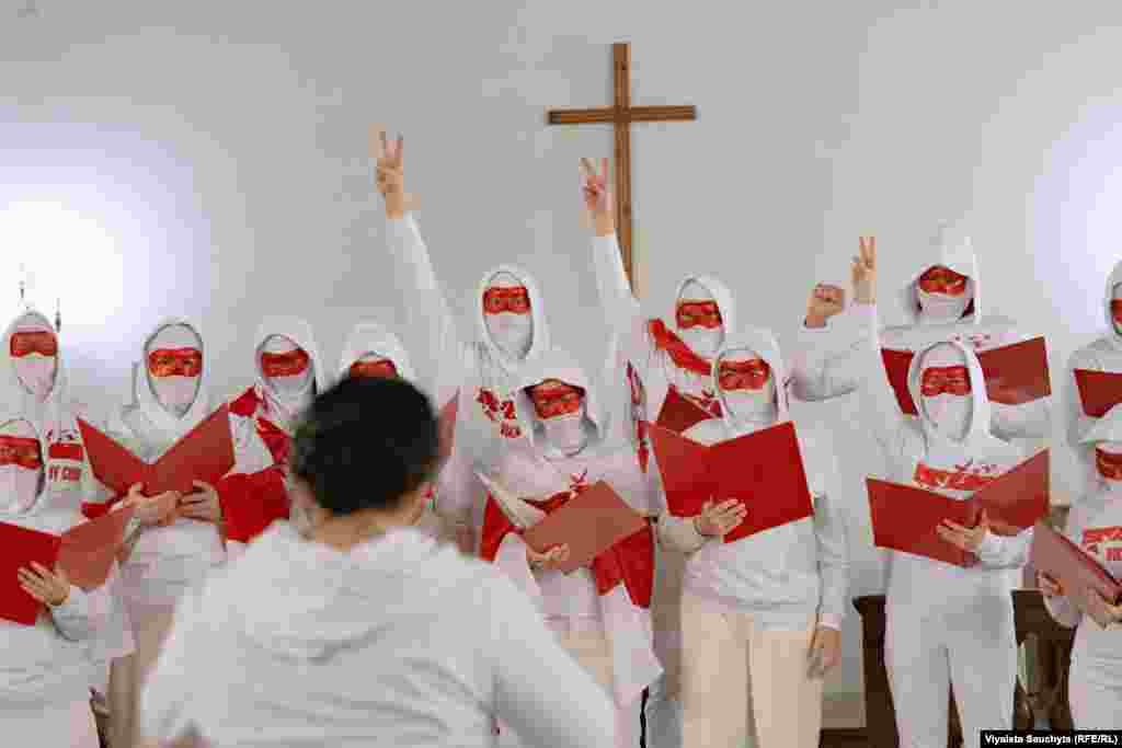 Exiled Belarusian singers calling themselves the Free Choir -- masked to protect their identities -- perform following the march. Before going into exile, the Free Choir sang in support of anti-government demonstrators and against the violent crackdown on protests in Belarus following the contested 2020 presidential vote. They now perform in European capitals like Warsaw and Berlin to draw international attention to the plight of Belarusians living under Lukashenka's authoritarian rule.