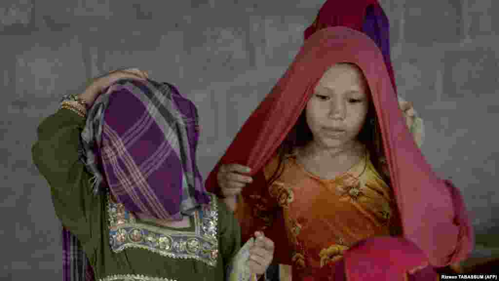 &nbsp;Afghan girls put on their scarfs at the refugee camp. At least 700 Afghans have been arrested since early September in Karachi alone -- 10 times more than in August -- and hundreds more in the other cities, according to official police figures.