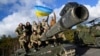 Ukrainian personnel pose with a flag on top of a Challenger 2 tank during training at Bovington Camp, near Wool in southwestern Britain, in February.
