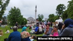 Posjetioci odmaraju na travnjaku ispred džamije Arnaudija neposredno pred ceremoniju otvaranja.