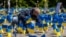 Украинские флаги и кресты с именами жертв: акция протеста, организованная активистами украинской диаспоры у мавзолея советских солдат в Варшаве 9 мая 2023 года