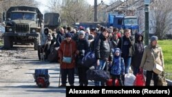 Evacuees wait to board a bus leaving the city of Mariupol in April. The data gleaned at filtration centers in Russia-controlled parts of Ukraine like Mariupol could be invaluable as the Kremlin moves forward with plans to hold so-called referendums in the occupied regions on joining Russia.
