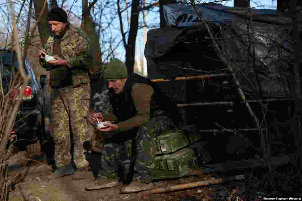 Soldiers with the Ukrainian Army's 10th Mountain Assault Brigade eat lunch during a lull in shelling next to their bunker at the front in the Bakhmut region on December 7. 