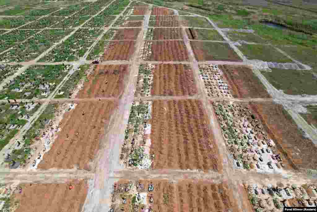 Rows of new graves in the Starokrymske cemetery photographed in May. The cemetery was massively expanded following the Russian takeover of the city, largely with graves marked only with a number. 