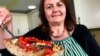 Tiziana di Costanzo, co-founder of Horizon Insects, holds up a slice of pizza made with cricket powder, in her London kitchen. (file photo)
