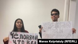 Qaragoz Qasym (left) and Aisultan Qudaibergen were detained at Almaty airport while holding posters saying: "Did you realize that you are cannon fodder?" and "Either respect or go away."