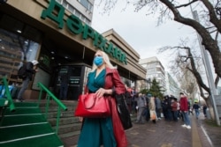 A woman walks down a street in Almaty on March 18.