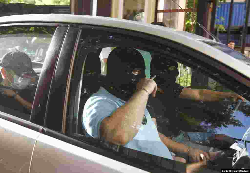 Masked men drive away after searching Navalny’s Moscow office on June 12, 2012. Navalny was later summoned for questioning by police, which prevented his participation in a planned protest.