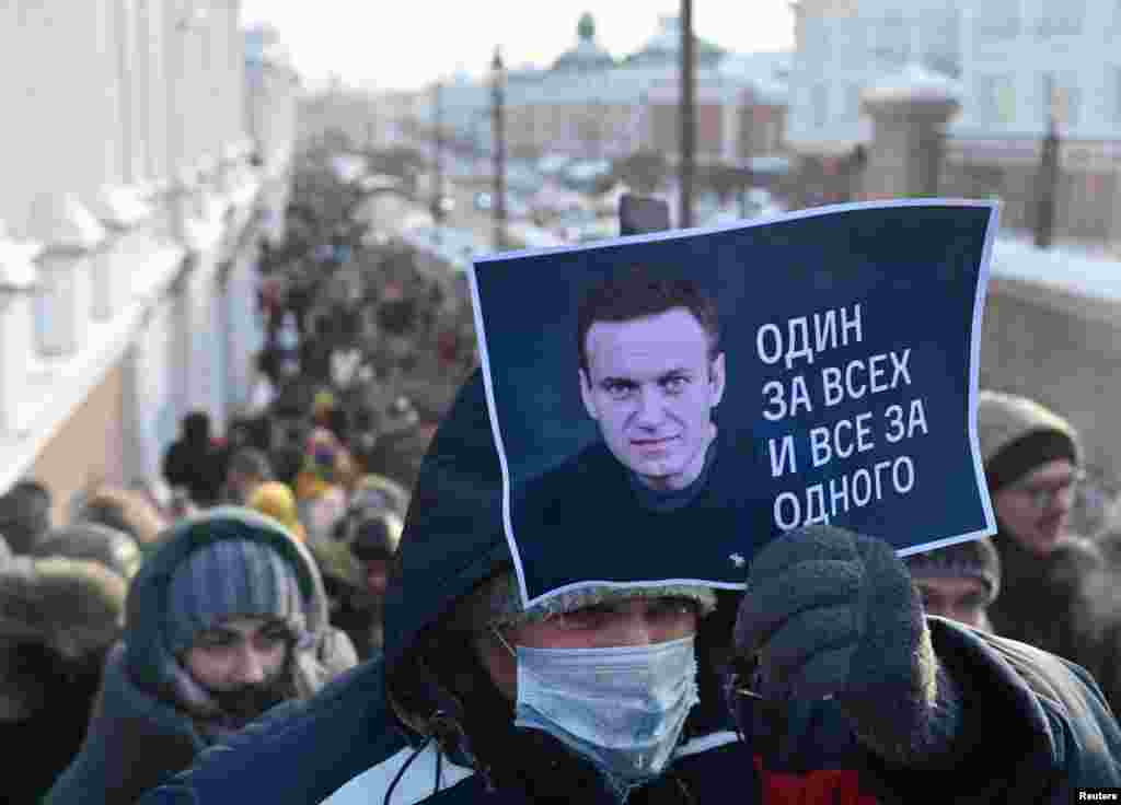 A man holds a placard reading "One for all, all for one" during a rally in Omsk.