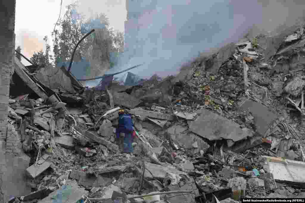 A rescue worker picks through the smoldering rubble of the collapsed building in Kyiv. Several residents of the building remain missing.