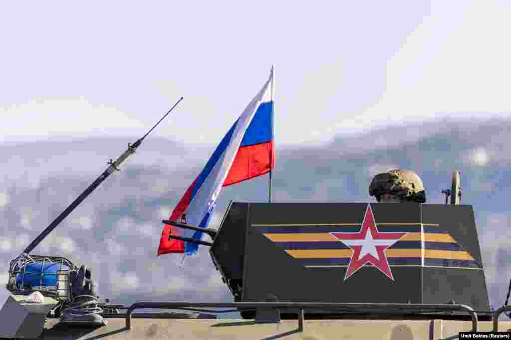 A Russian gunner in the turret of an armored vehicle as it approaches the Hmeimim air base. "It's not possible to communicate with the Russian soldiers," photographer Bektas says. "They don't answer questions and they don't let you get close. They look tense, but not angry, they didn't show any kind of violence or anything like that," he adds. "They are keeping their composure." 