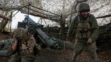 Ukrainian servicemen fire a self-propelled howitzer towards Russian troops near the frontline town of Pokrovsk