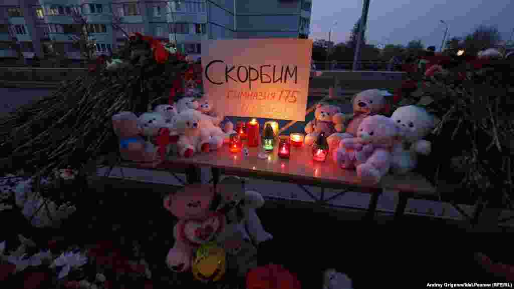 A sign reads, "We grieve."