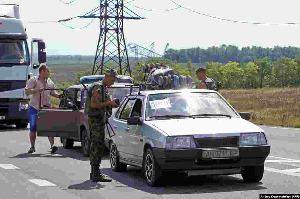 A Ukrainian serviceman checking documents at a checkpoint near Maryinka in August 2014. 