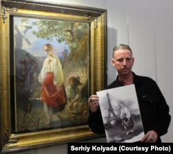 Serhiy Kolyada holds one of his works in front of a painting by 19th century poet and artist Taras Shevchenko, both featuring a figure named Kateryna.