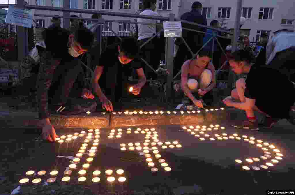 People place lit candles on the ground to form the school's number 175 in Kazan on May 11.