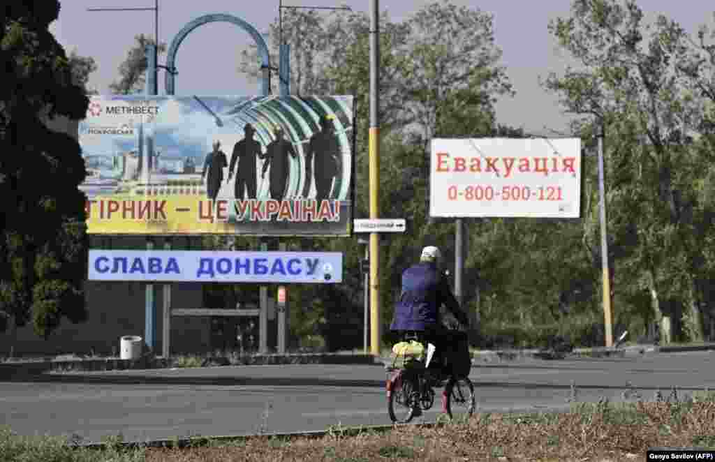 Signs in Pokrovsk including one (right) displaying a phone number for people who want to be evacuated. Around 13,000 residents were believed to remain in the city as of October 4. 