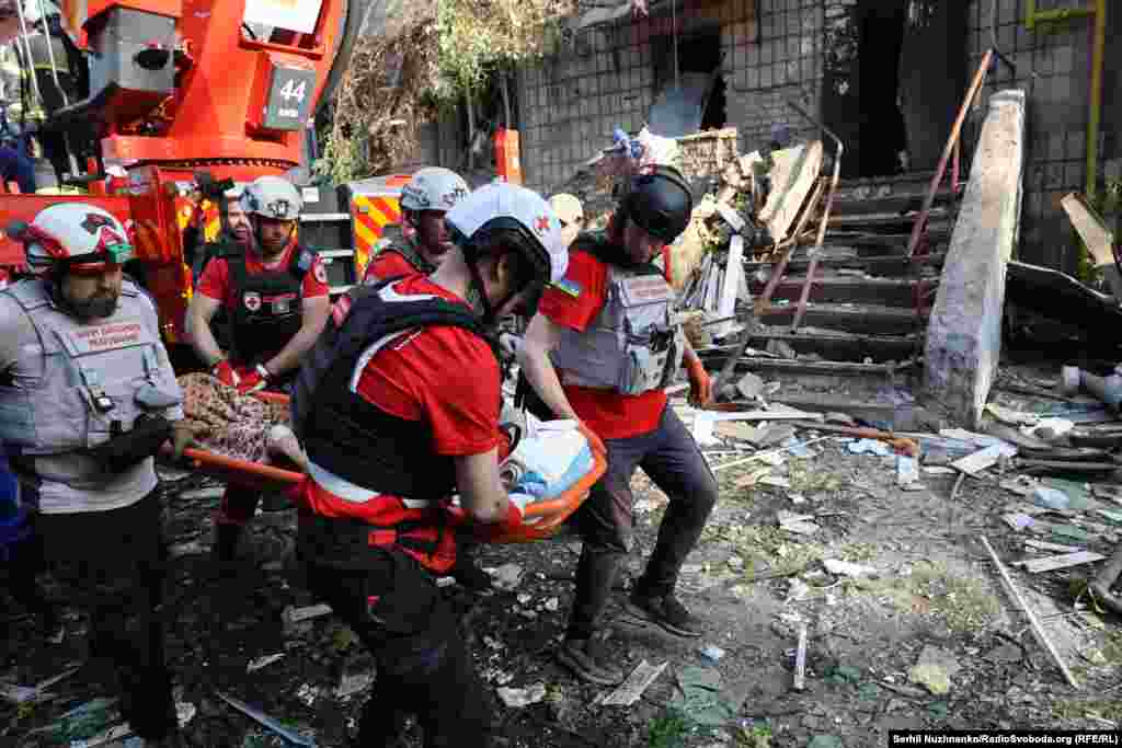 A wounded resident is evacuated from the site of a Russian strike in Kyiv. 