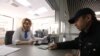 A clerk checks a migrant's passport at a migrant center in the city of Krasnogorsk, outside of Moscow. Will the new requirements help migrants, or just present another opportunity for corruption?
