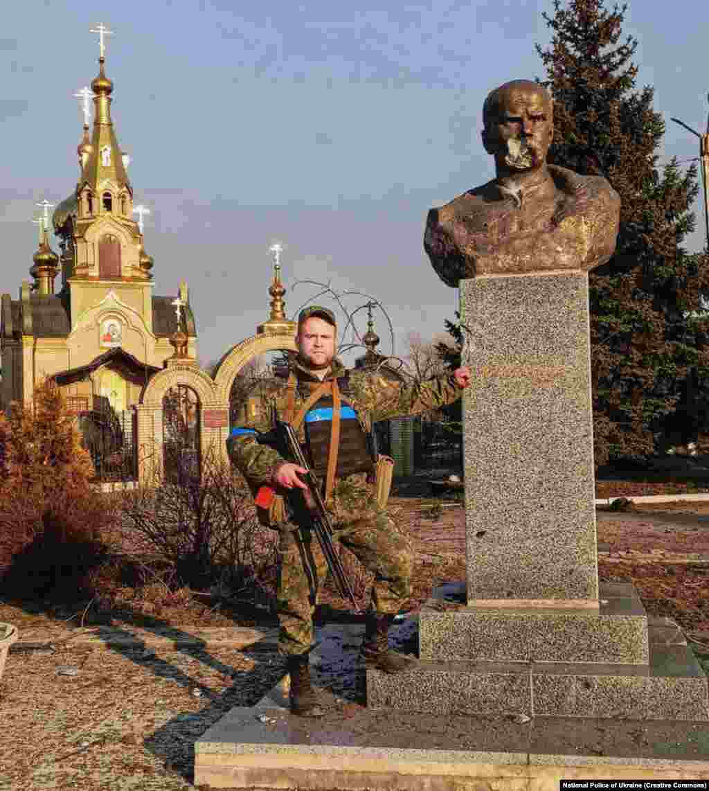 A Ukrainian soldier poses next to the Shevchenko monument in March 2022. 