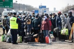 Many Ukrainian migrants line up to go home after the announcement that the Polish-Ukrainian border crossing at Dorohusk was to be closed following a coronavirus outbreak in March..