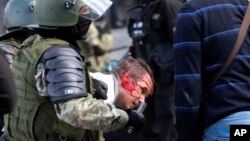 Riot police violently detain a protester during an opposition rally in Minsk against the election results.
