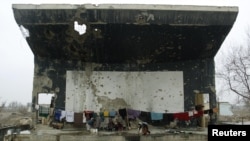 Afghan refugees live on the destroyed stage of the outdoor theater at the former Soviet Cultural Center in Kabul in December 2002.