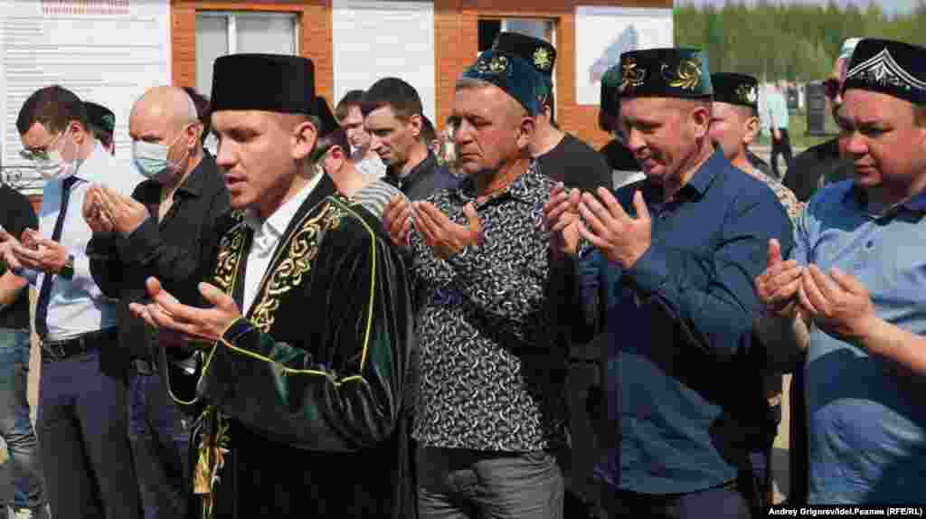 People pray at the students' funeral.