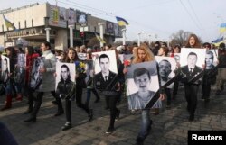 People carry portraits of local residents killed in fighting with pro-Russian separatists during a commemoration rally in Kharkiv on February 22.