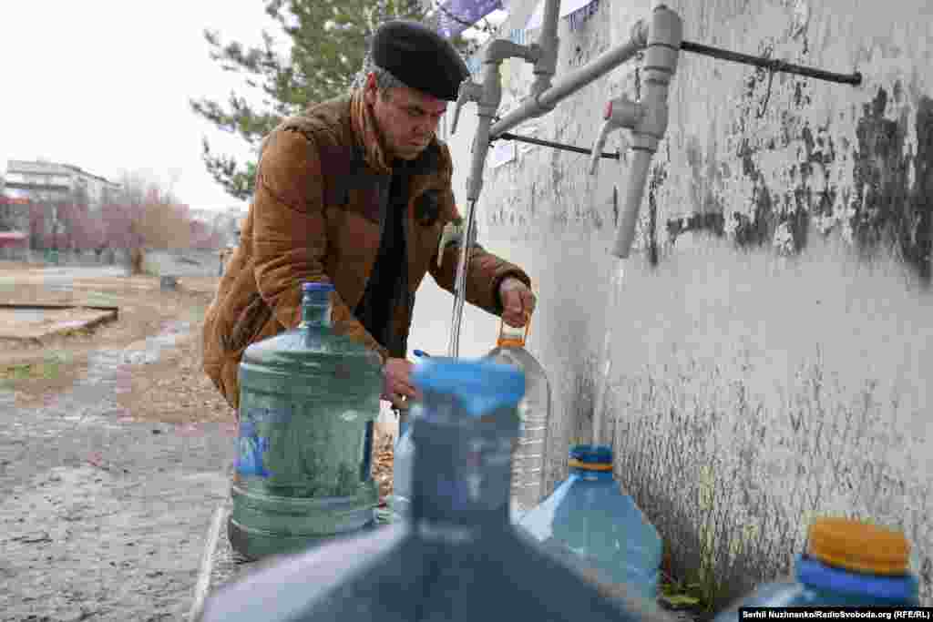 A Pokrovsk resident collects water from one of a handful of supply points in the city. One of the biggest challenges for Pokrovsk's residents is sourcing water. Locals say that Russian forces destroyed water pumping stations outside the city in August 2022, and since then most water has been sourced from tankers organized by local government and aid organizations. 