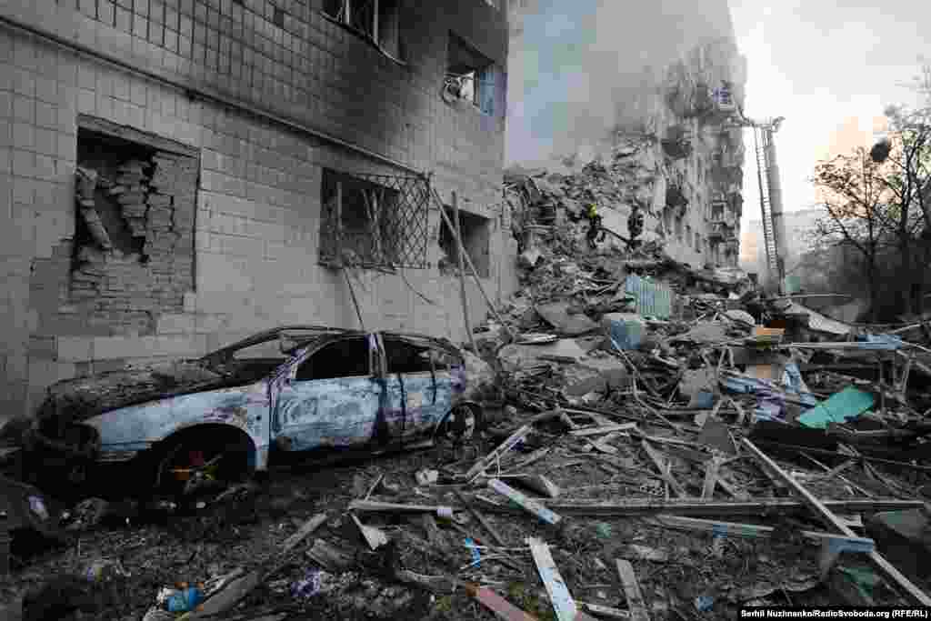A burned car alongside the collapsed section of the Kyiv apartment block.