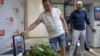 Arkady Babchenko (right) reacts as he arrives in the offices of ATR TV, where his colleagues laid flowers by a portrait of him in his memory, in Kyiv on May 31.
