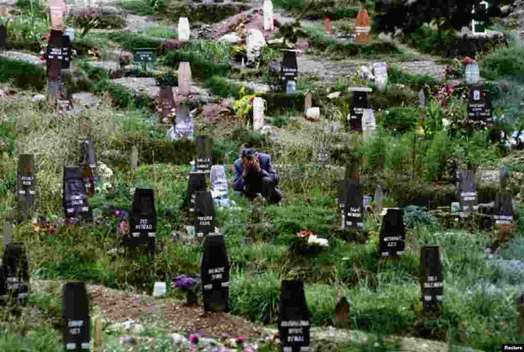 A man mourns his wife in one of Sarajevo's ever-expanding cemeteries in 1993. 