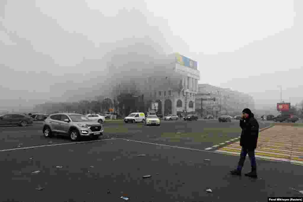 A man watches the Almaty office of Kazakhstan's state broadcaster burn on January 6. 