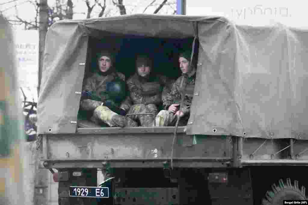 Ukrainian soldiers are seen in a military vehicle in Mariupol.