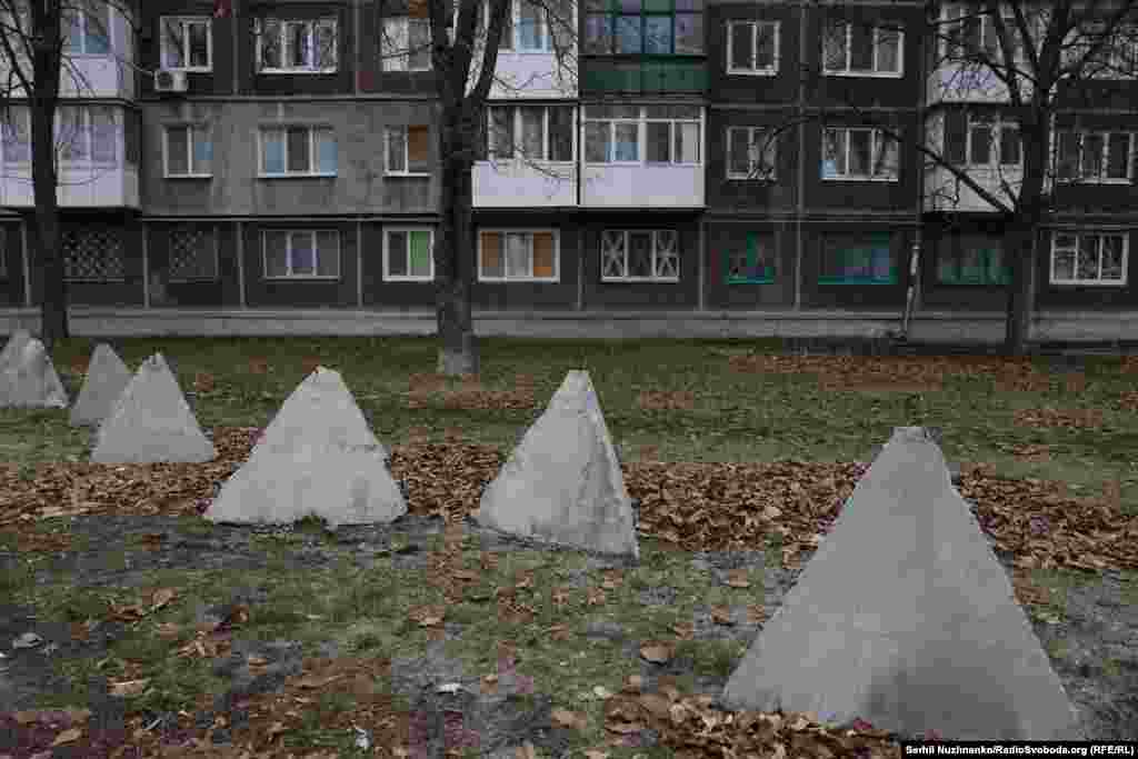 "Dragon's teeth" anti-tank obstacles in Pokrovsk. Suppliers for Yaroslavovna's grocery shop still come every weekday, she tells us, but some drivers are afraid to come into the city center. “We meet them behind the bridge and transfer the products, then drive them in ourselves.” If Russian troops keep pushing closer, Yaroslavovna says, “I’ll close the shop and flee with the dogs and cats that I’m looking after here. I definitely won’t live here under the Russians, if the front gets any closer. But for now, I’ll be here for as long as I can." 