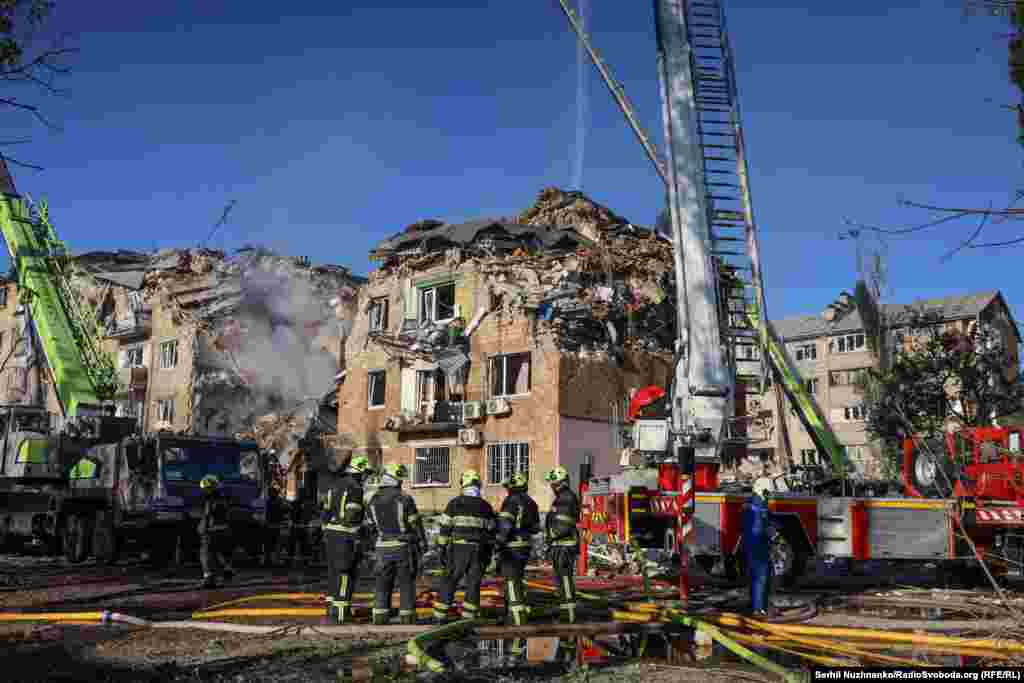 Rescuers used extension ladders and specialized equipment to reach the upper floors of a damaged building in Kyiv's Darnytskiy district, which was badly hit.