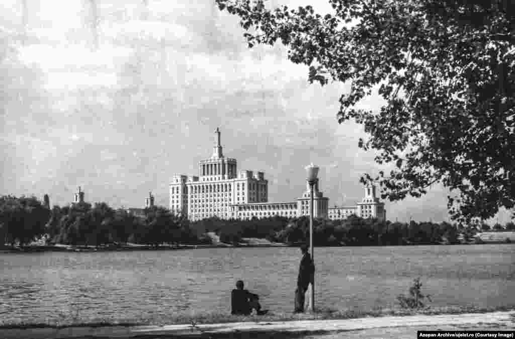 Men look over Herastrau Lake in Bucharest toward the House of the Spark, a building that housed a state-run newspaper in Ceausescu's Romania. Szocs is one of the founders of Azopan, an open-access photo archive of largely amateur photos from Romania’s 20th century, meaning the infrastructure needed for the Uj Elet archive was already largely in place. 