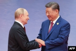 Қытай және Ресей басшылары ШЫҰ саммитінде қол алысып тұр. Тяньцзинь, 31 тамыз 2025 жыл.